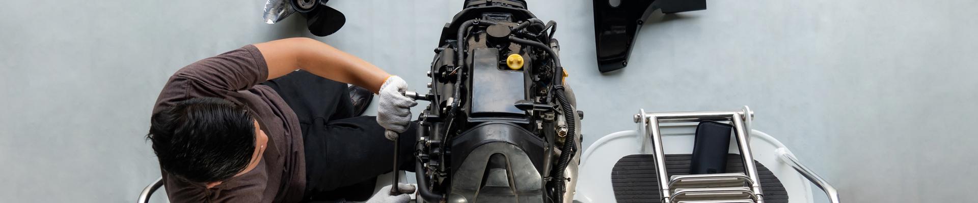 Service Technician working on lower unit of an outboard motor at Wye Heritage