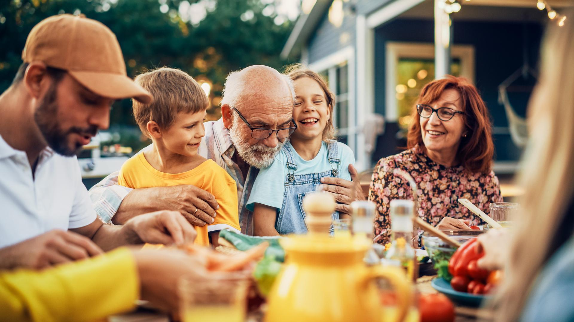 Family enjoying dinner outside their cottage